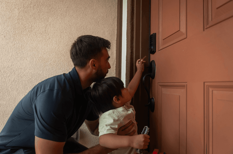 Jaden helping a young child unlock the door of a new home